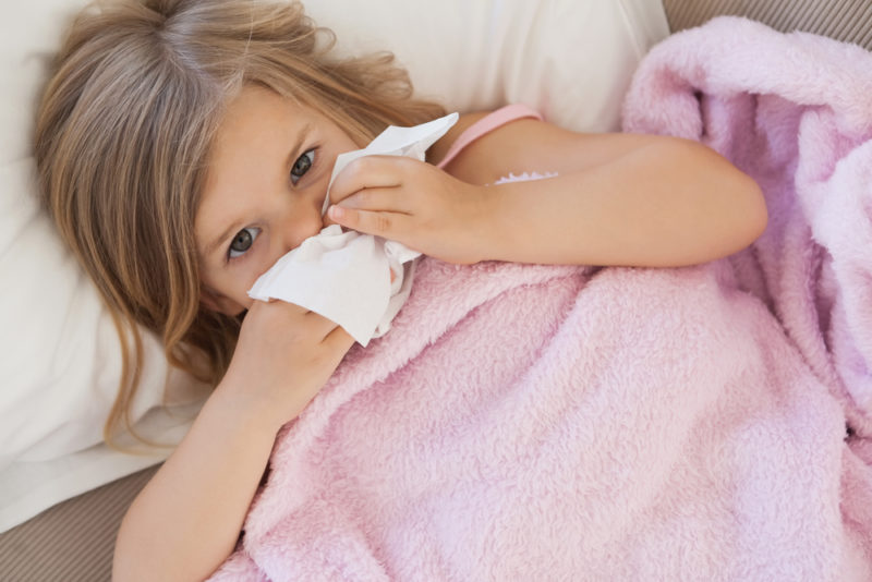 little girl blowing her nose