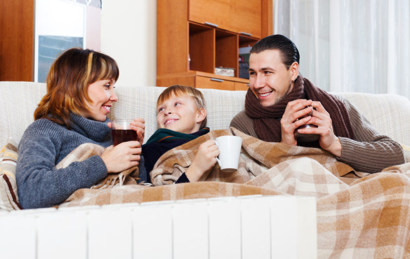family sitting on couch holding beverages