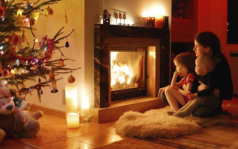 mother and children sitting by the fireplace