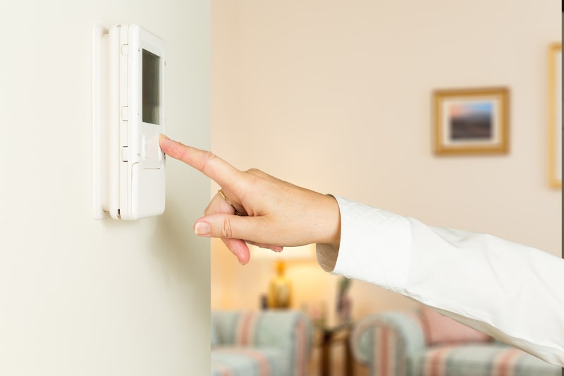 hand reaching out to adjust thermostat
